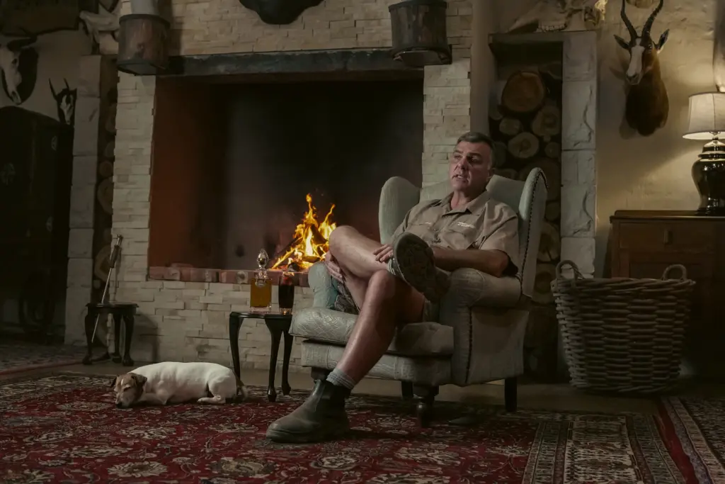 A hunter relaxing by the fire in a South African hunting lodge