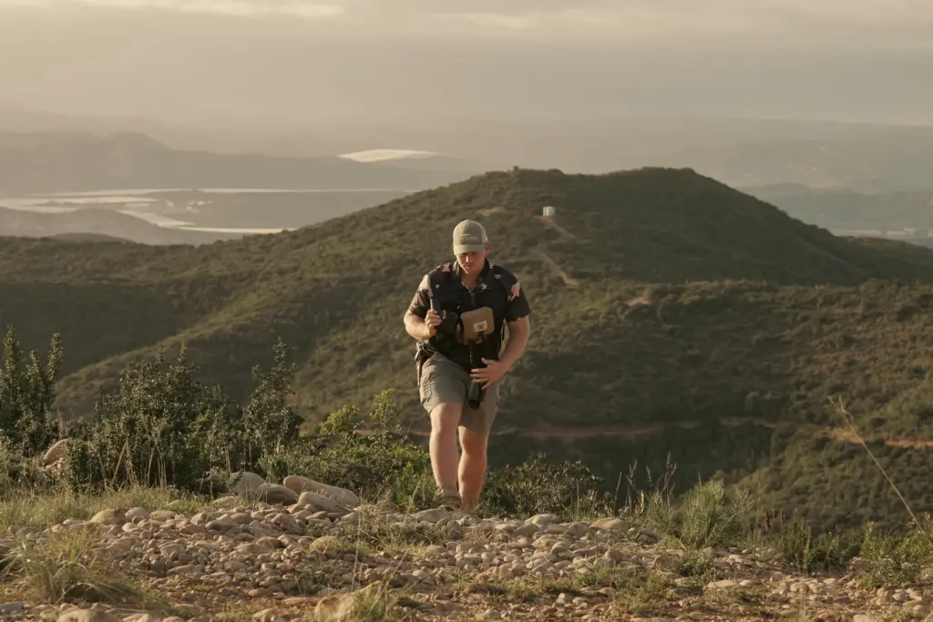 A hunter walking a ridge above a valley in the Eastern Cape